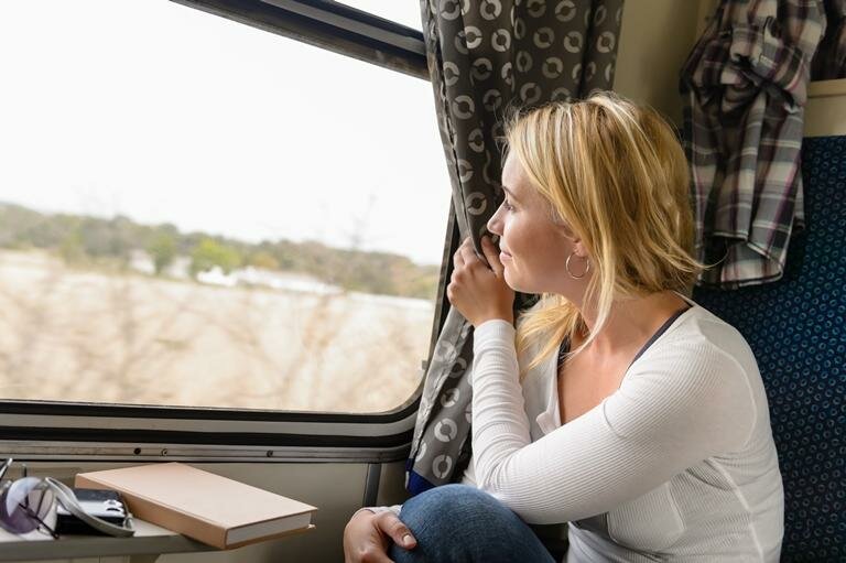 женщина смотрит в окно поезда